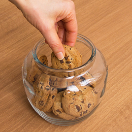 Photo of a hand pulling a cookie out of a cookie jar